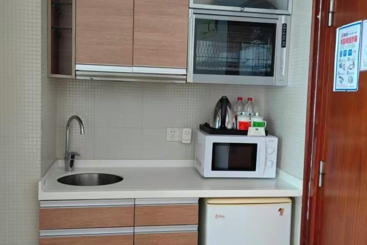 A compact kitchenette with a sink, microwave, and storage drawers.