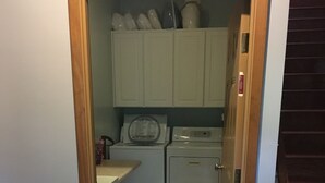 Une buanderie équipée d’un lave-linge, d’un sèche-linge et de placards.