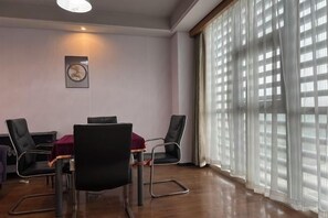 A conference room with a table, chairs, and a clock on the wall. - Tianhai Hotel (Jiujiang The Second Yangtze River Bridge Harbor) (Jiujiang)
