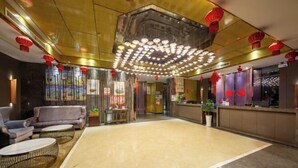 A spacious lobby with a central seating area, a reception desk, and a decorative ceiling light fixture. - Tianhai Hotel (Jiujiang The Second Yangtze River Bridge Harbor) (Jiujiang)