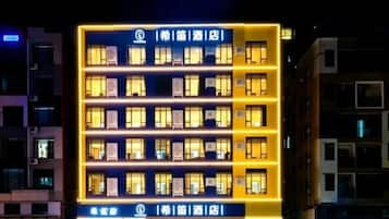 A multi-story hotel building with illuminated windows and signage.