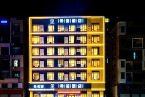 A multi-story hotel building with illuminated windows and signage. - XiDi Hotel (Shenzhen)