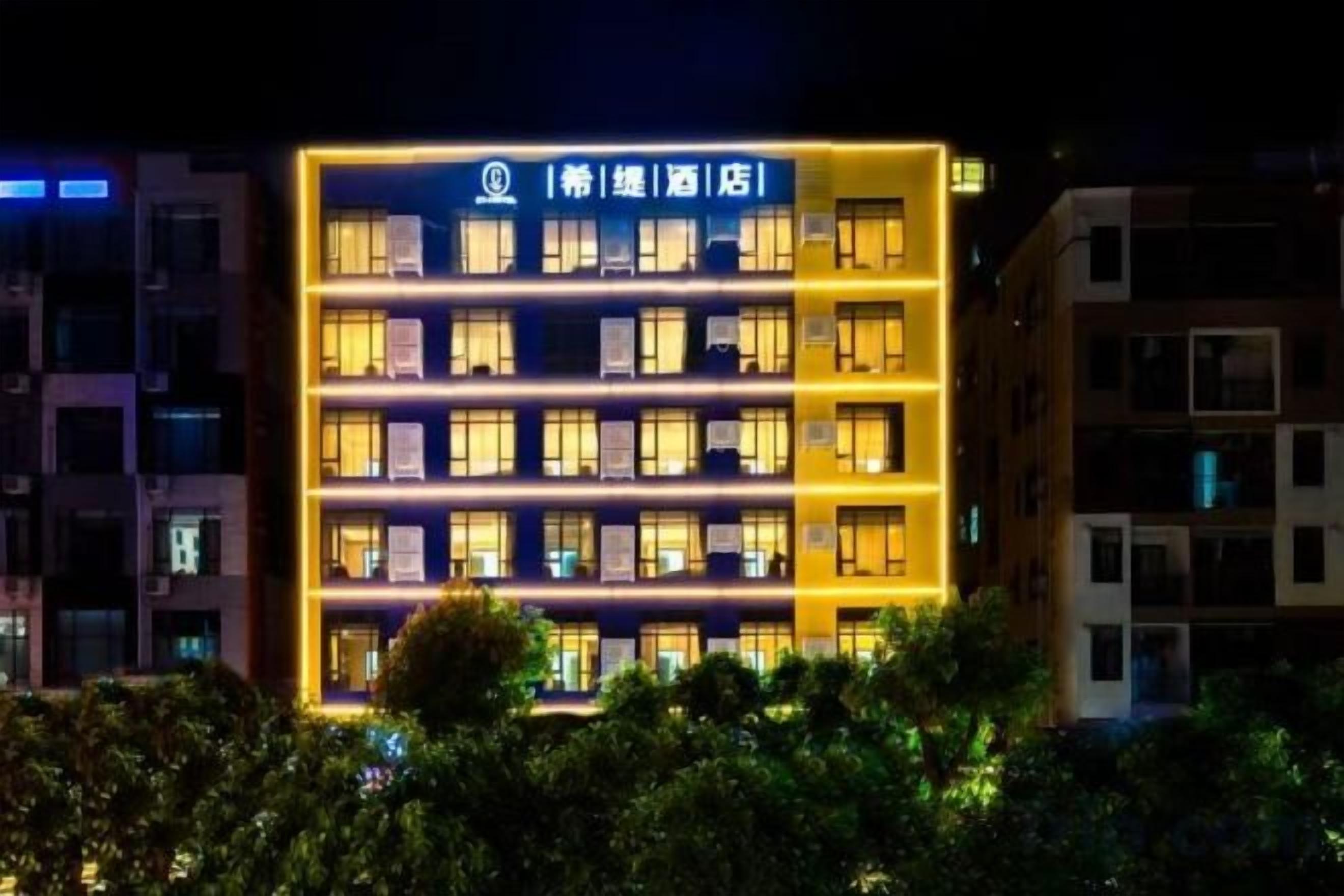 Edifici d'hotel de diverses plantes amb cartells il·luminats i finestres.