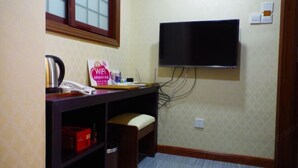 Una habitación con escritorio, silla y televisión montada.