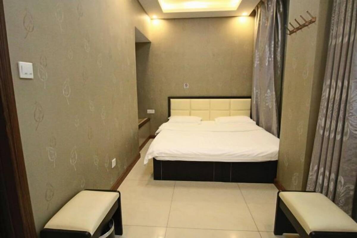 A bedroom with a large bed, two bedside tables, and a headboard.
