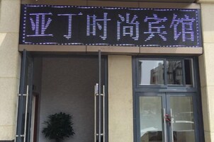 A hotel entrance with a digital sign displaying Chinese characters.