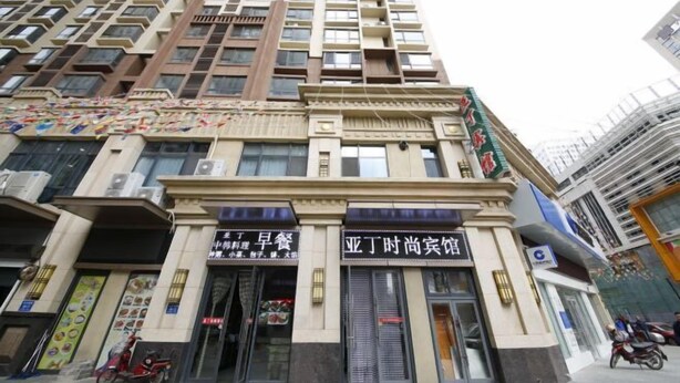 Un edificio de varios pisos con locales comerciales en la planta baja, incluyendo un restaurante y una tienda de conveniencia.