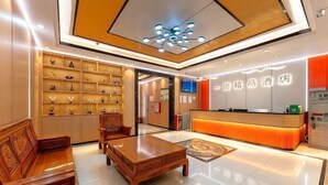 A hotel lobby with a reception desk, seating area, and a wall of trophies. - Zhaoqing Duanxu Hotel (Fortune Plaza) (Zhaoqing)