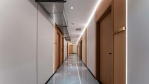 A long, narrow hallway with doors on both sides, a tiled floor, and recessed lighting. - Zhaoqing Duanxu Hotel (Fortune Plaza) (Zhaoqing)