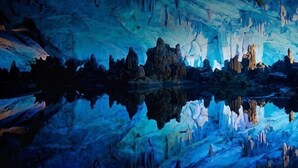 An interior of a cave with stalactites and stalagmites, a reflective floor, and a rocky ceiling. - Zhaoqing Duanxu Hotel (Fortune Plaza) (Zhaoqing)