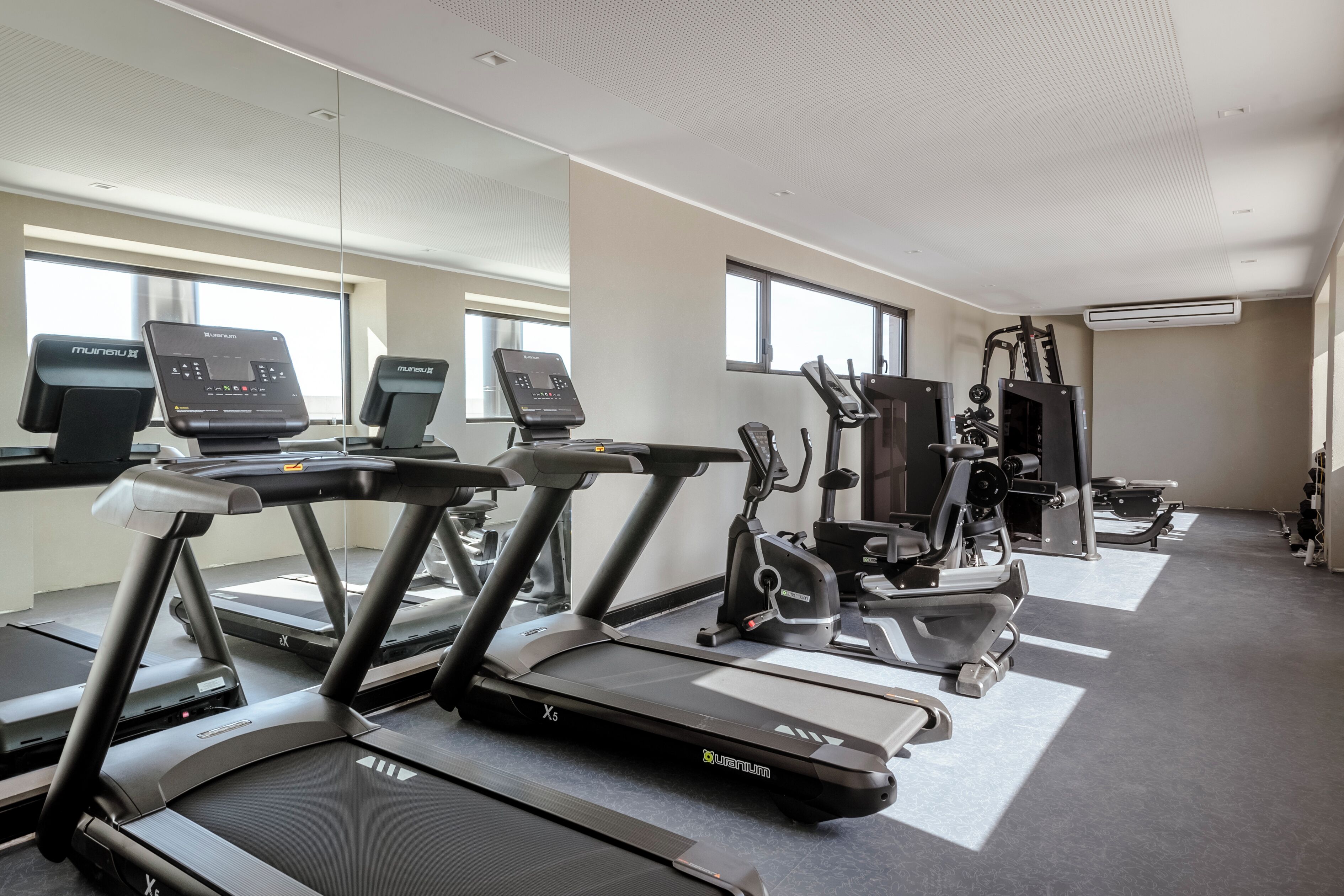 Un gimnàs amb nombroses cintes de córrer, bicicletes d'exercici i màquines de musculació.