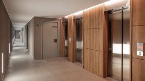 A modern hallway with two elevators, a door labeled "11", and a digital display showing "7:15". - Top Rentals Nuñez (Buenos Aires)