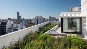 A rooftop terrace with a city view, modern architecture, and a glass-enclosed area. - Top Rentals Nuñez (Buenos Aires)