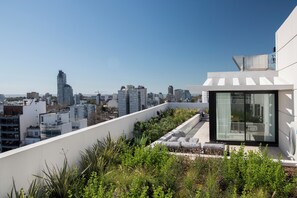 A rooftop terrace with a city view, modern architecture, and a glass-enclosed area. - Top Rentals Nuñez (Buenos Aires)