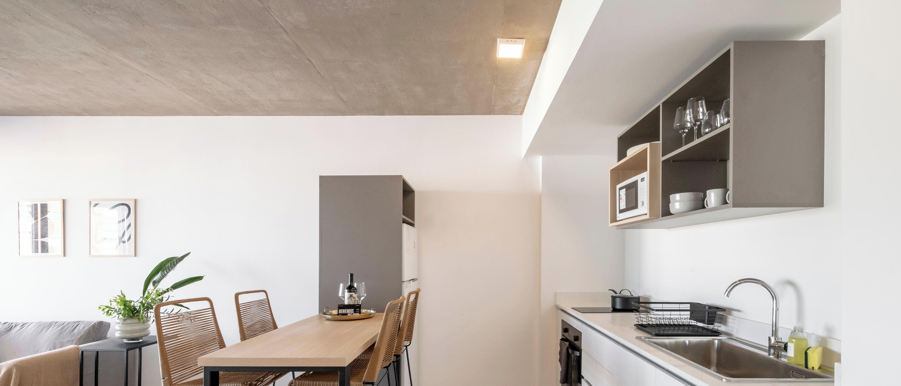 Una cocina moderna con microondas integrado, un lavamanos y una encimera.