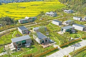A residential area with modern houses, a well-maintained lawn, and a clear view of the surrounding landscape. - Luoping Golden Valley Taijia SPA Hotel (Luoping)