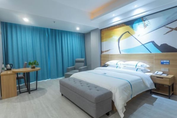 A modern hotel room with a large bed, a desk, a chair, and a small table with a plant. - Lanli Baihe Hotel (xindacheng 2 Road) (Yangjiang)