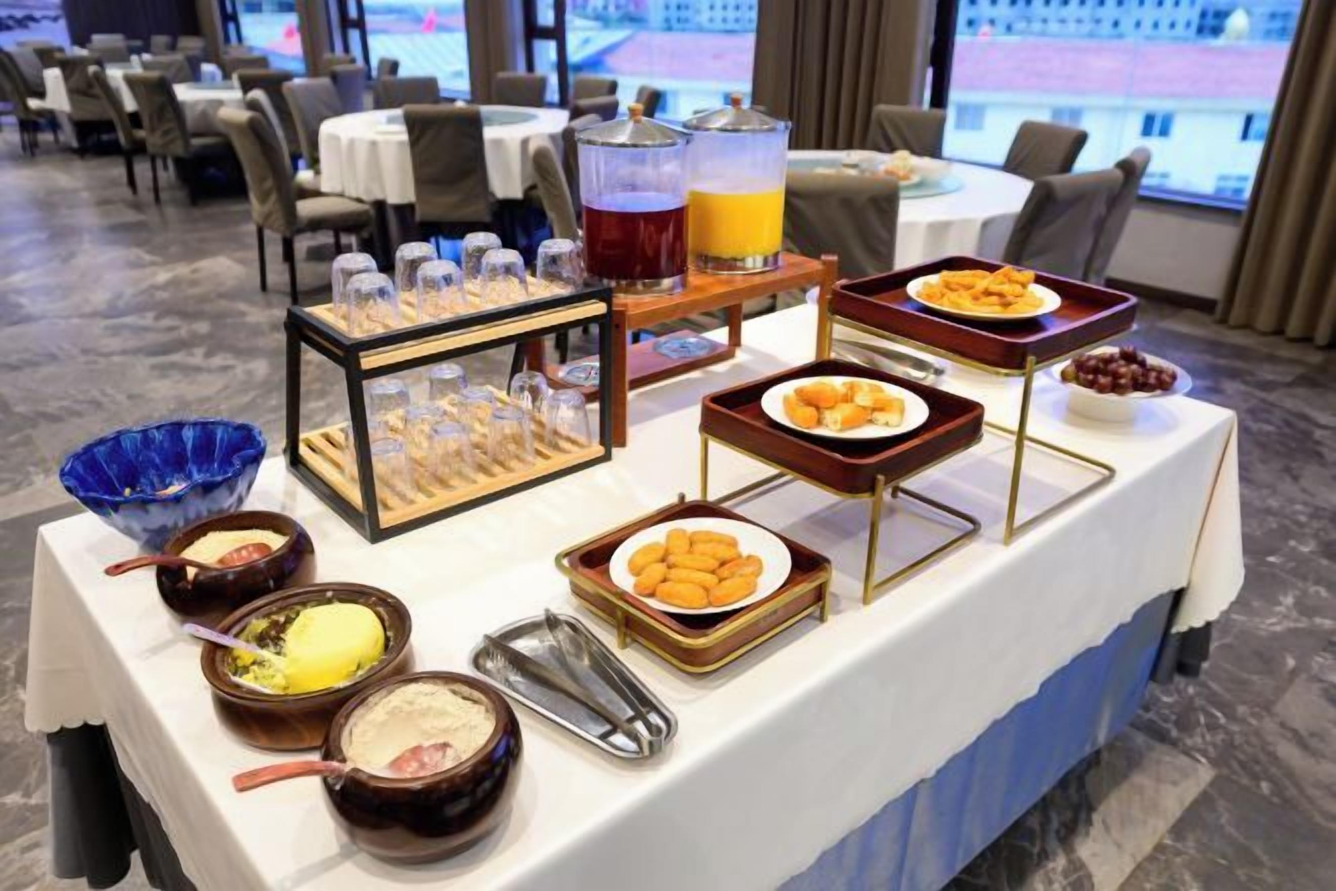 A buffet table with various food items and a fruit punch dispenser.