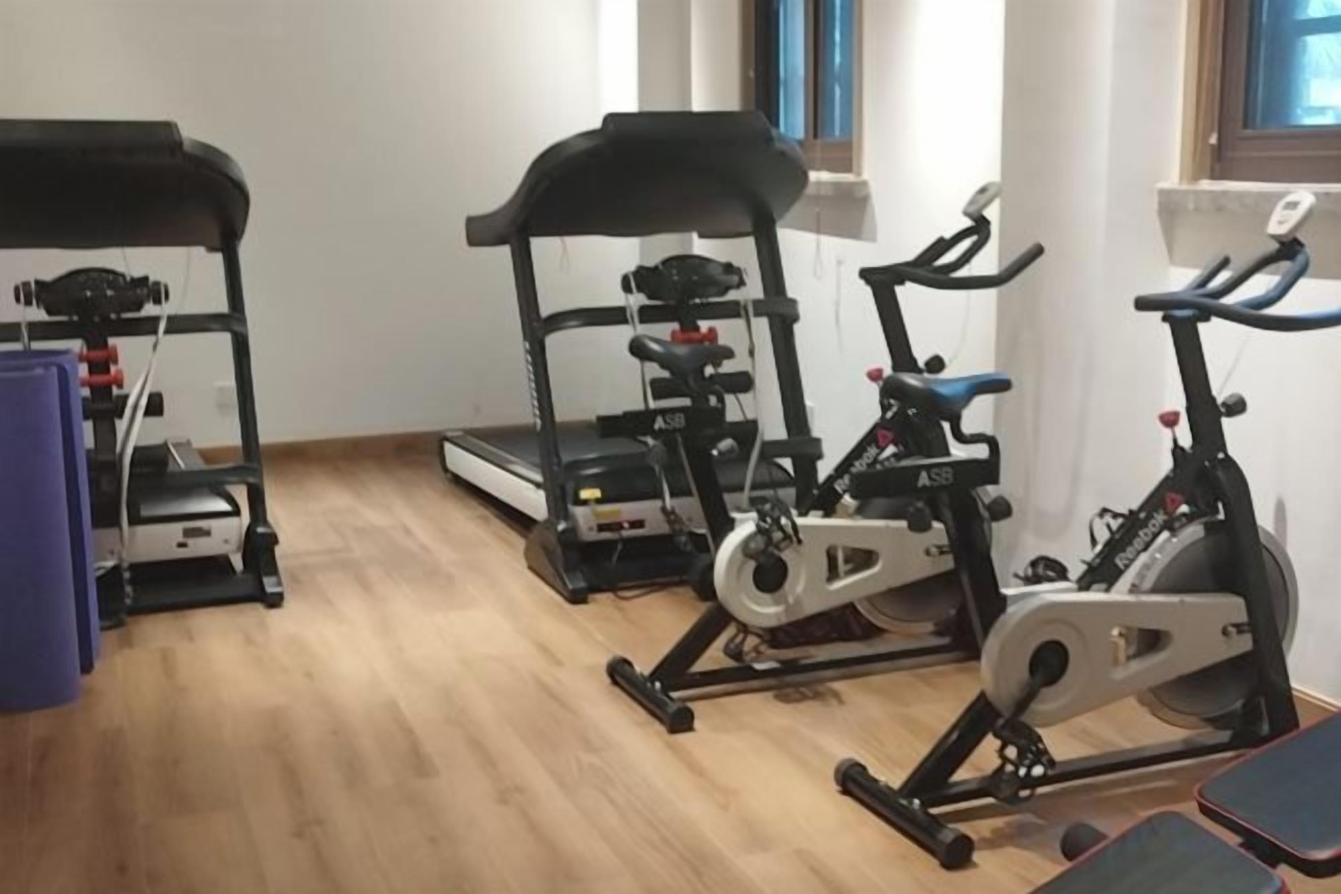 A gym with treadmills, an elliptical, and a stationary bike.