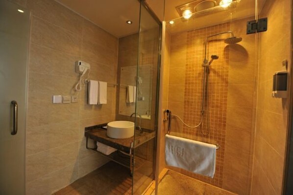 A modern bathroom with a glass-enclosed shower, a sink with a mirror, and a towel rack. - Coffey Hotel (Hongyuan)