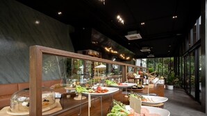 A modern dining area with glass display cases, wooden tables, and a view of greenery outside. - Timberton Resort Khaoyai (Pak Chong)