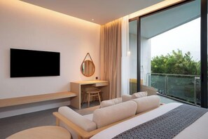 Habitación de hotel moderna con una cama grande, un escritorio, una silla, un televisor y un balcón con vistas.