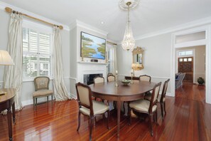 Enjoy meals in this traditional dining room with a wooden table, six comfortable chairs, and a stunning chandelier.