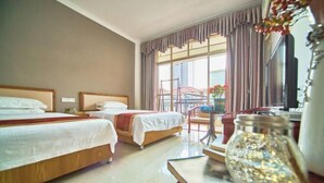 A hotel room with two beds, a dining table, a chair, and a large window with curtains. - Hongdou Lanting Inn (Renhua)