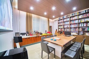 Una cocina moderna con comedor, estantería y un amplio ventanal.