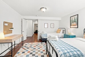 A bedroom with a bed, bedside table, lamp, and a painting on the wall.