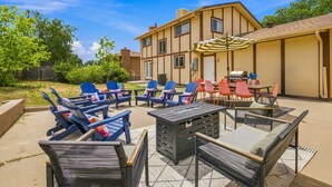 An outdoor patio with lounge chairs, a table, and a grill area. - Themed Bedrooms, Movie Room & Firepit Yard (Westminster)