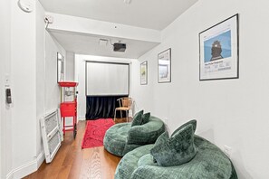 A hallway with a red Nostalgia vending machine, a projector, and a framed poster of The Polar Express.