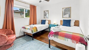 A bedroom with two beds, a ceiling fan, and a window with curtains. - Themed Bedrooms, Movie Room & Firepit Yard (Westminster)