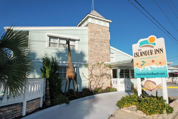 A building with a sign for The Islander Inn, featuring a brick tower and a white facade.