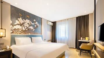 Habitación de hotel con una cama grande, un escritorio con silla, un televisor de pantalla plana y un aire acondicionado instalado en la pared.