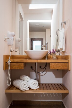 Bathroom features a central sink, hairdryer, and towel rack.