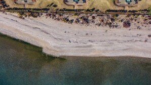 An aerial view of a coastal residential area with multiple houses, each featuring a central courtyard and a swimming pool. - Nahuel 2nd Floor Lake View Dina Huapi Bariloche (Dina Huapi)