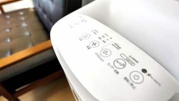A remote control with Japanese symbols and text, placed on a white surface.
