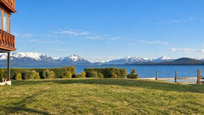A grassy area with a wooden deck and a view of a lake and snow-capped mountains. - Mascardi Fivefold Ground Floor LakeView Dina Huapi (Dina Huapi)