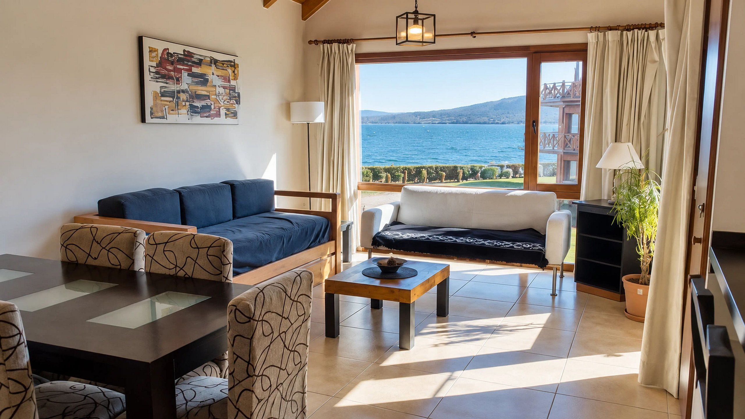 Una sala de estar con sofá, mesa de comedor y vista al mar.