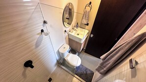 Een moderne badkamer met toilet, wastafel en spiegel.