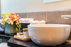 A bathroom sink with a large bowl, a vase with flowers, and a tray with toiletries. - NEW Great Stay in Roma 24-7 Security (Mexico City)