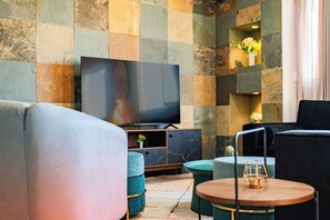 A modern living room with a flat-screen TV, plush seating, and a decorative glass table. - NEW Great Stay in Roma 24-7 Security (Mexico City)
