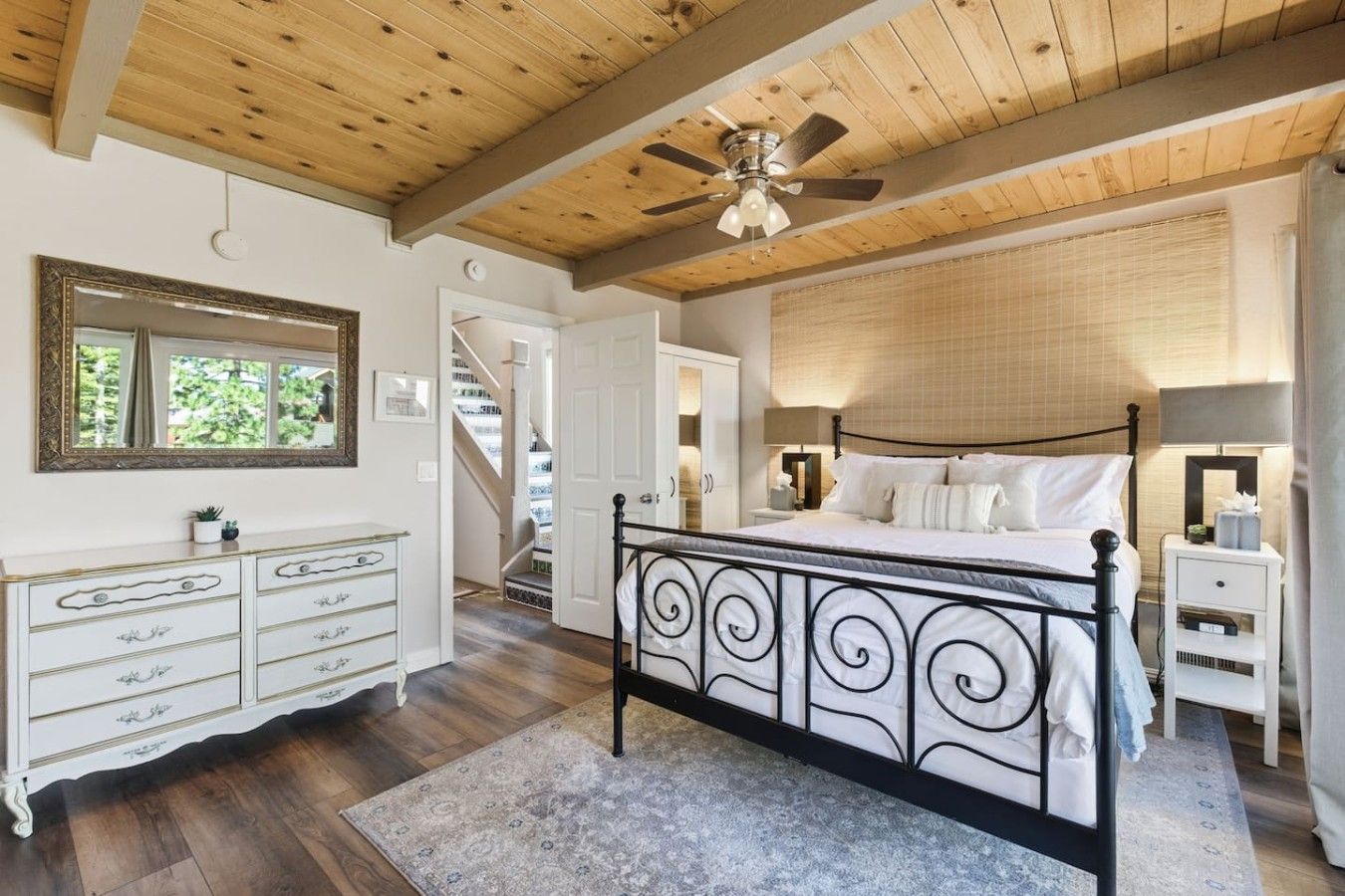 Quarto com cama, cômoda e ventilador de teto.