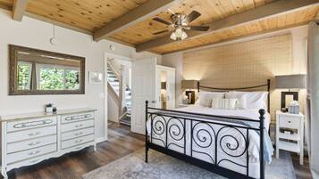 Quarto com cama, cômoda e ventilador de teto.