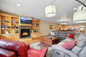 A living room with a fireplace, a sofa, a coffee table, and a television.