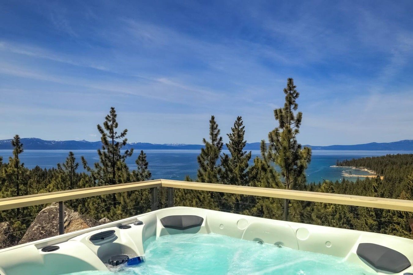 Un bain à remous avec une vue panoramique sur un lac et des montagnes.
