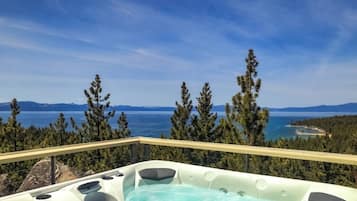 Un bain à remous avec une vue panoramique sur un lac et des montagnes.