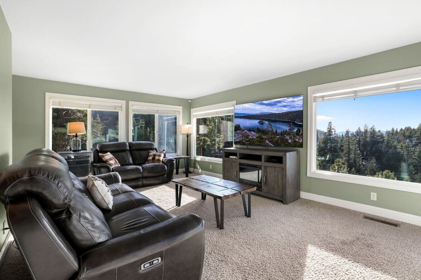 A living room with a leather sofa, a coffee table, and a TV on a stand.