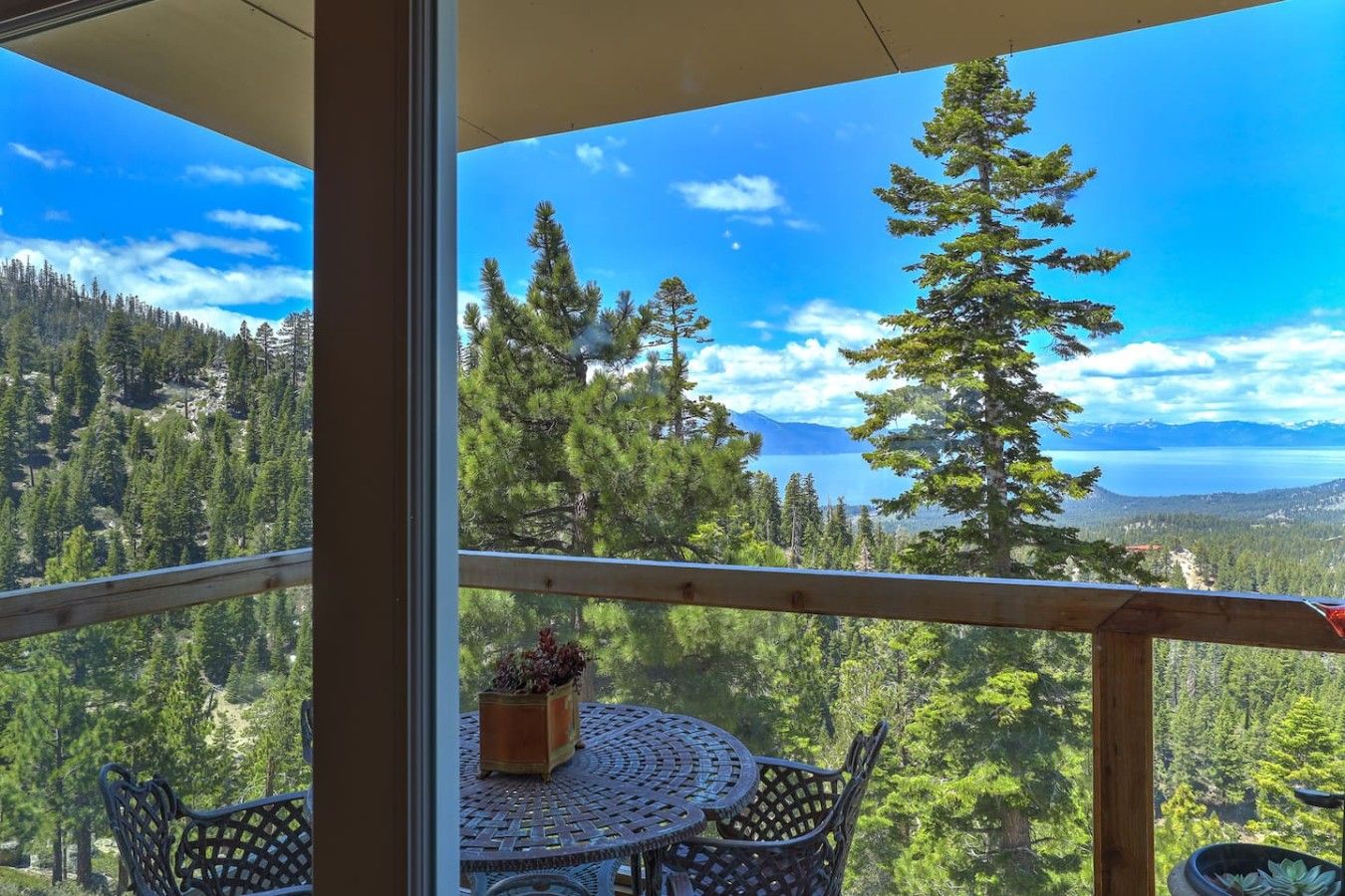 Un balcón con vistas a un bosque y montañas.